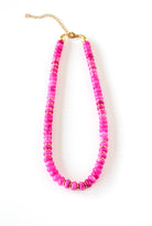 a pink beaded necklace on a white background