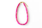a pink beaded necklace on a white background
