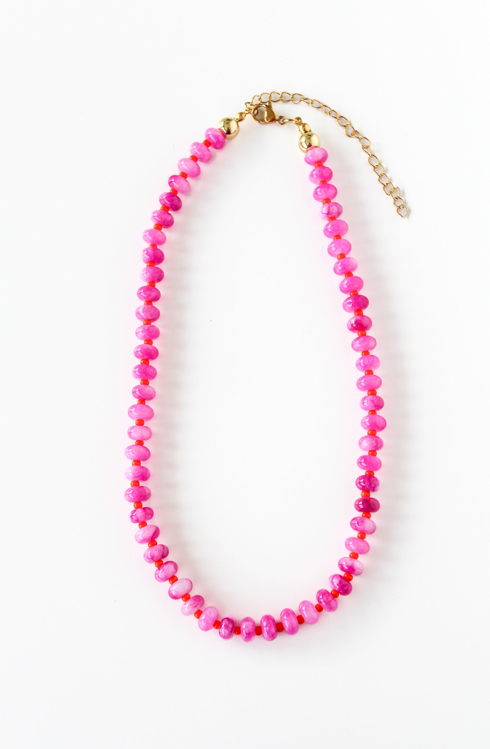 a pink beaded necklace on a gold chain
