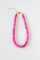 a pink beaded necklace on a white background