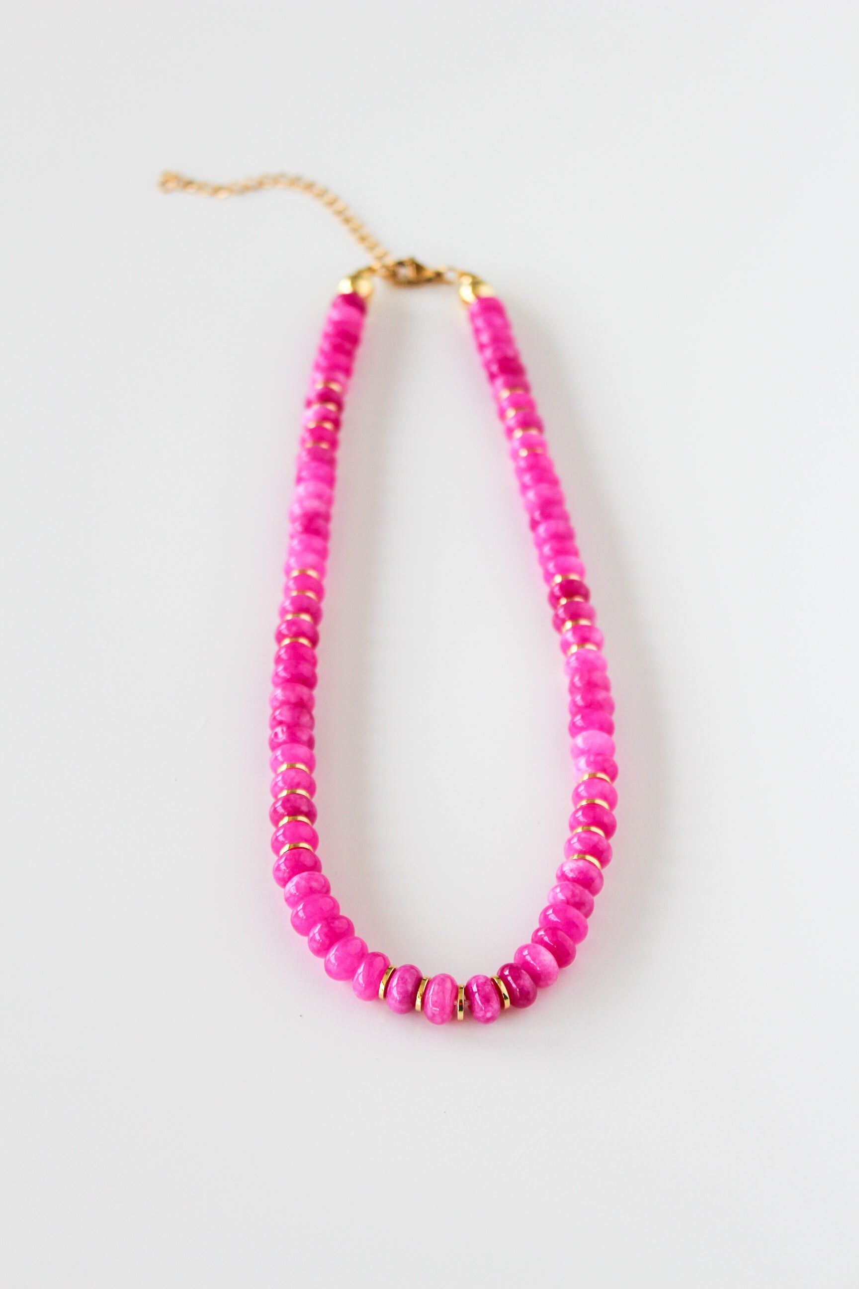 a pink beaded necklace on a white background