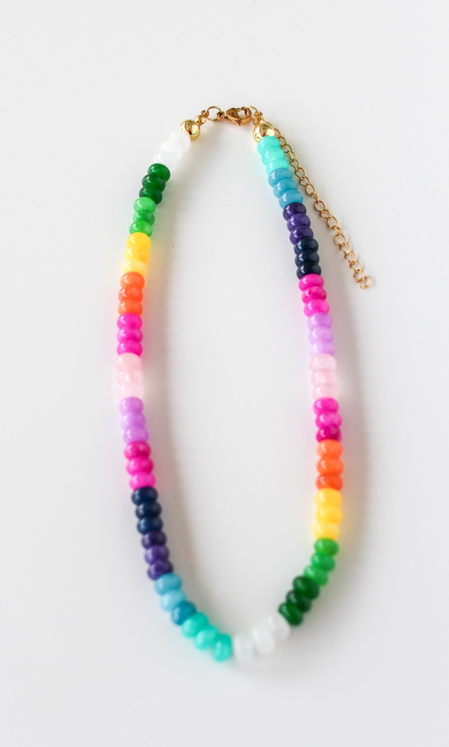 a multicolored beaded necklace on a gold chain