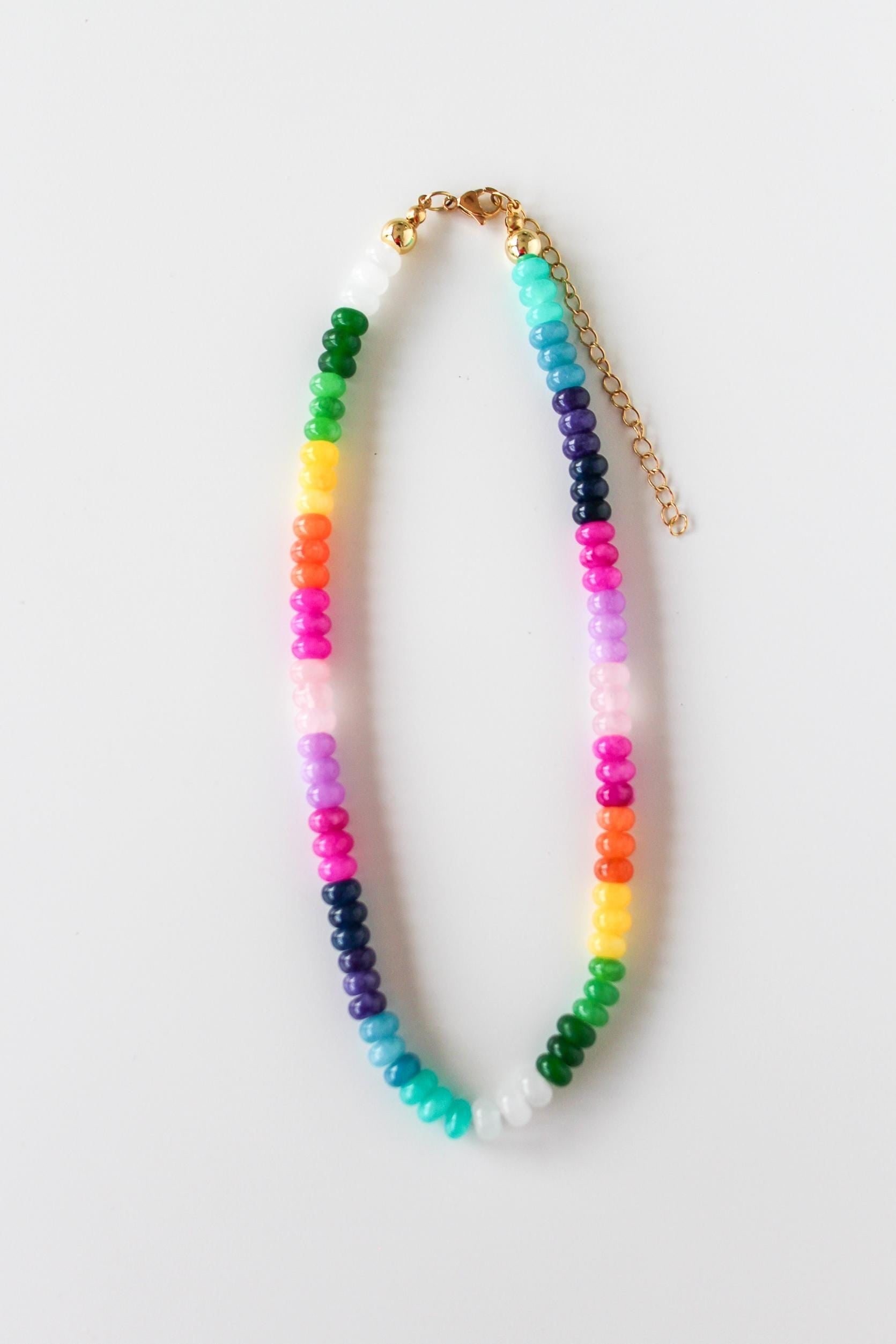 a multicolored beaded necklace on a gold chain