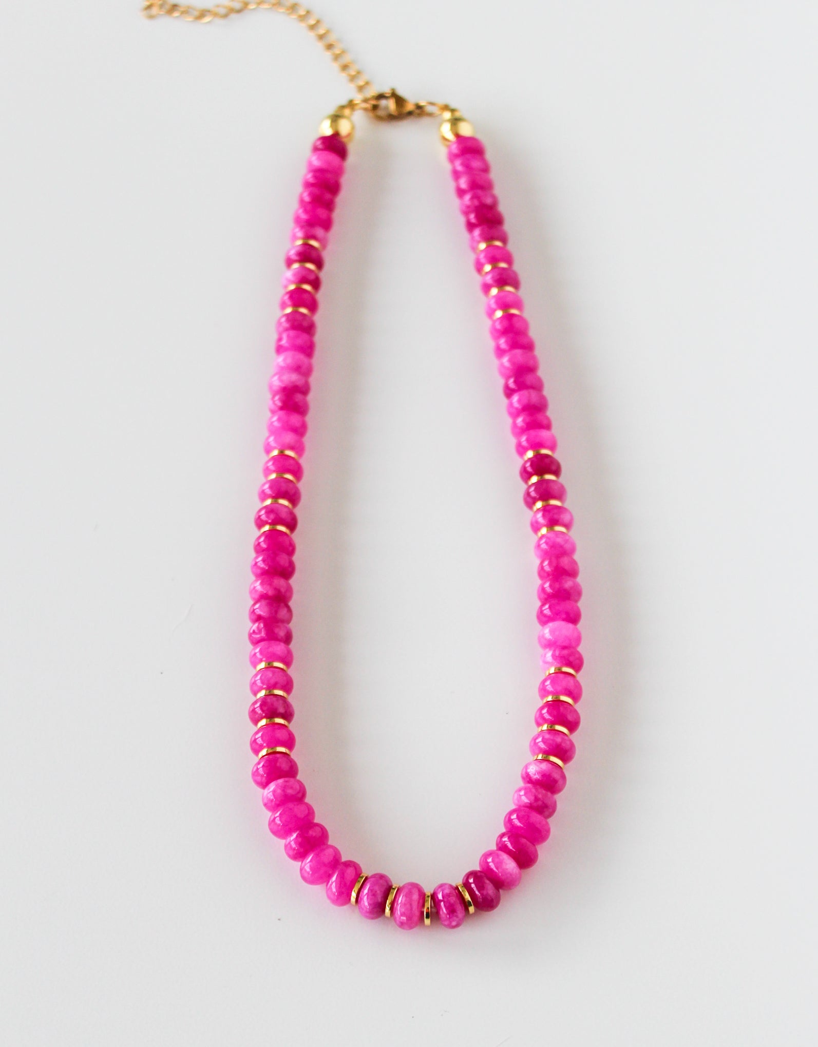 a pink beaded necklace on a gold chain